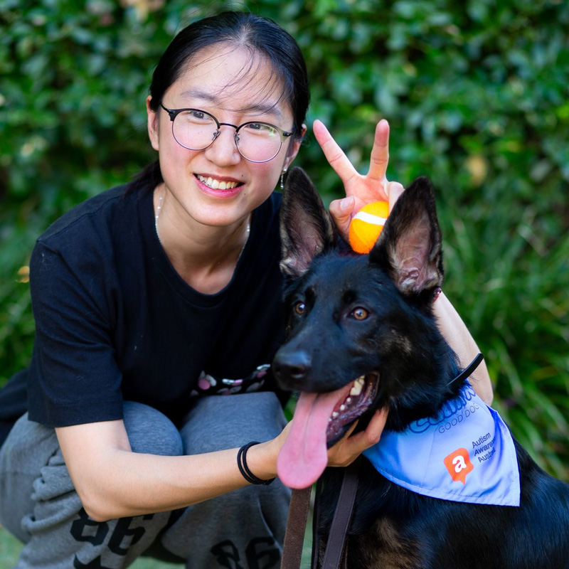 A woman and her dog are posing for the camera.