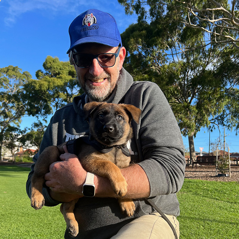 A man holding a dog in his arms.