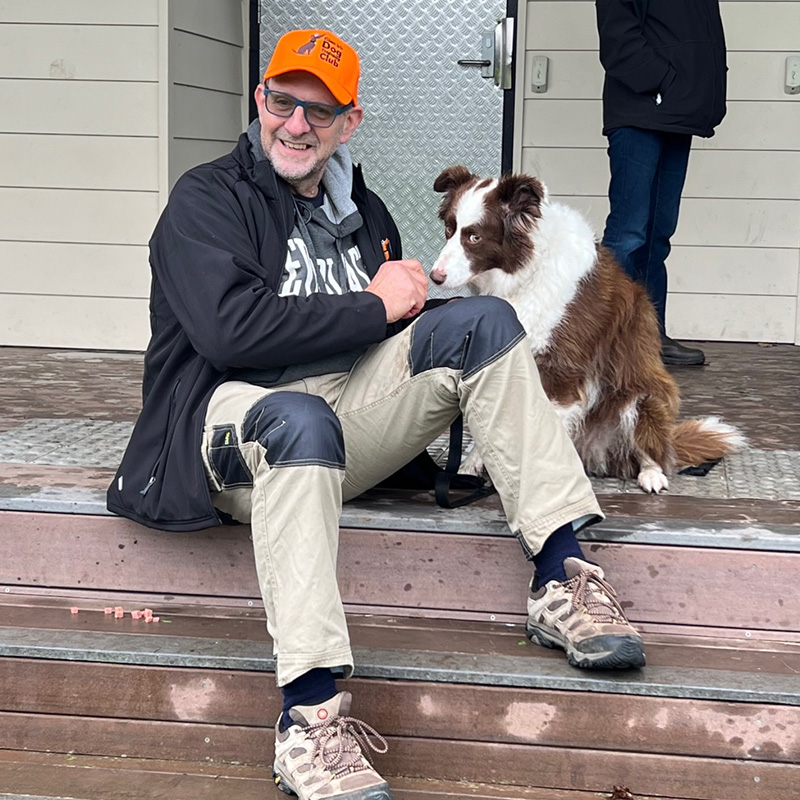 A man sitting on the steps with his dog.